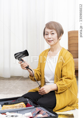旅行の荷造りをするシニア女性 130908812
