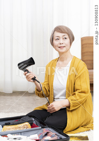 旅行の荷造りをするシニア女性 旅行の荷造りをするシニア女性 130908813