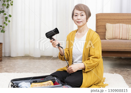 旅行の荷造りをするシニア女性 130908815