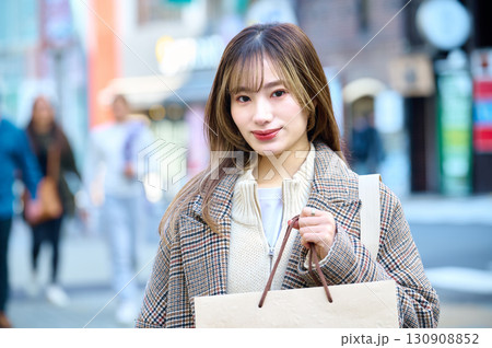 ショッピングバックを持つ冬服の女性 130908852