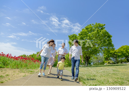 ポピーの咲く公園を歩く3世代家族 130909522