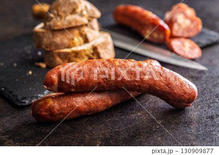 Smoked sausages on black table. Smoked sausages on black table. 130909877
