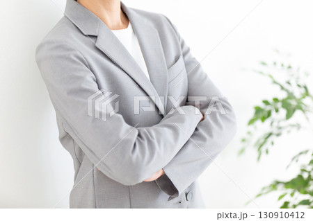 腕組みをするグレーのスーツ姿のミドル女性ビジネスウーマン 腕組みをするグレーのスーツ姿のミドル女性ビジネスウーマン 130910412