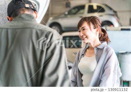 車のエンジンルームで女性客に説明,解説をする整備士,メカニックの男性スタッフ 130911132