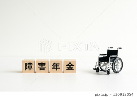 白背景に木製ブロック「障害年金」とミニチュア車椅子を配置した障害年金のコンセプト 130912054