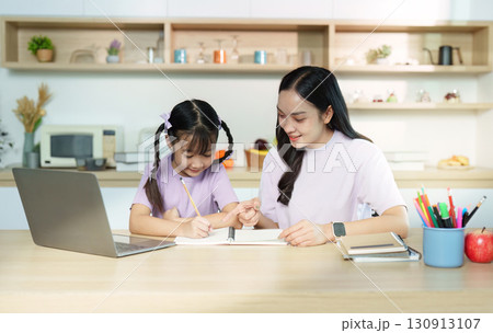 Back to School. Mother helping daughter with homework at kitchen table. Back to School. Mother helping daughter with homework at kitchen table. 130913107