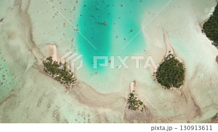 French Polynesia, Rangiroa island: Crystal clear turquoise waters gently caressing the shores of picturesque motus in Rangiroa, French Polynesia. Wild nature travel landscape. Drone flight French Polynesia, Rangiroa island: Crystal clear turquoise waters gently caressing the shores of picturesque motus in Rangiroa, French Polynesia. Wild nature travel landscape. Drone flight 130913611