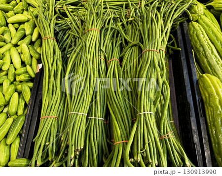 Bundles of fresh green long beans neatly tied and displayed at a grocery market Bundles of fresh green long beans neatly tied and displayed at a grocery market 130913990