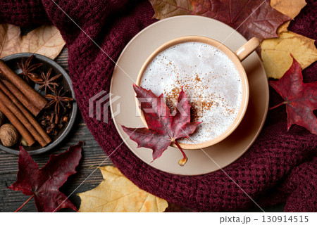 Autumn latte coffee with maple leaf and cozy plaid 130914515