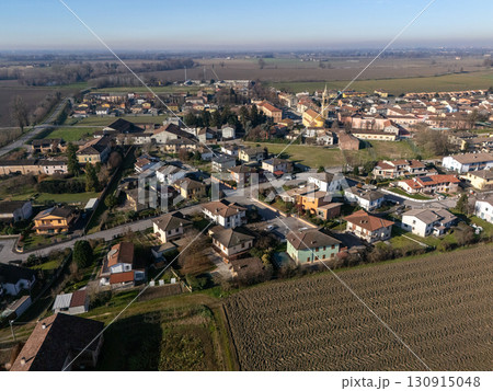 Stagno Lombardo, Italy showing countryside and residential homes under blue sky 130915048