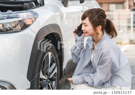 自動車の前でスマホで電話するアジア人女性（ロードサービス・トラブル・レスキュー・困る） 130915137