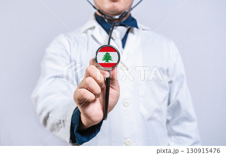 Doctor hands holding stethoscope with Lebanon flag. Lebanon health and care concept Doctor hands holding stethoscope with Lebanon flag. Lebanon health and care concept 130915476