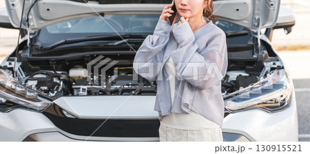 自動車の前でスマホで電話するアジア人女性（ロードサービス・トラブル・レスキュー・困る） 130915521