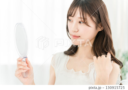 鏡を見てスキンケアをするアジア人女性（美容,ビューティー,化粧品,肌,アンチエイジング） 130915725