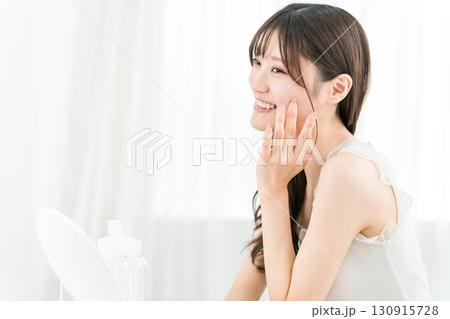 鏡を見てスキンケアをするアジア人女性（保湿,美容,ビューティー,化粧品,肌,アンチエイジング） 130915728
