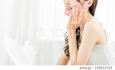 鏡を見てスキンケアをするアジア人女性（保湿,美容,ビューティー,化粧品,肌,アンチエイジング） 130915729