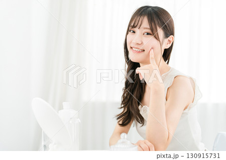 鏡を見てスキンケアをするアジア人女性（保湿,美容,ビューティー,化粧品,肌,アンチエイジング） 130915731