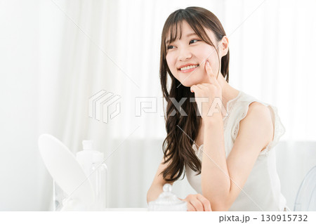 鏡を見てスキンケアをするアジア人女性（保湿,美容,ビューティー,化粧品,肌,アンチエイジング） 130915732