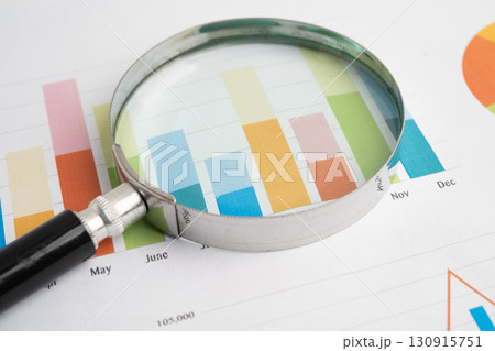 Magnifying glass on data business graphs paper. 130915751
