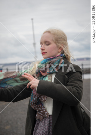 Cute woman in season coat posing outdoors 130915866