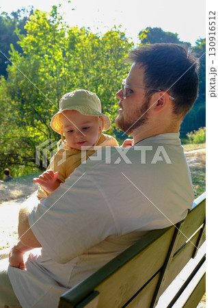 Father and Baby Relaxing in Sunny Park 130916512