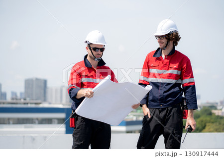 Two engineer checking solar energy system looking blueprint for planning installation solar panel. Two engineer checking solar energy system looking blueprint for planning installation solar panel. 130917444