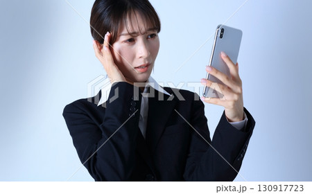 スマホとネガティブな女性会社員イメージ 130917723