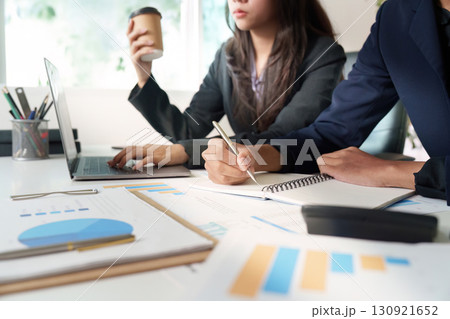 Professional Meeting. Businesswoman taking notes while colleague presents data. 130921652
