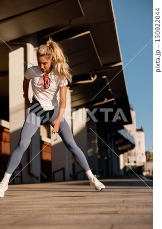 Young woman engaging in an outdoor fitness workout during a sunny day Young woman engaging in an outdoor fitness workout during a sunny day 130922044