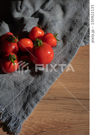Red tomatoes on grey kitchen towel Red tomatoes on grey kitchen towel 130922135