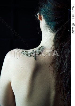 Butterfly sitting on woman shoulder close-up over dark background Butterfly sitting on woman shoulder close-up over dark background 130922928