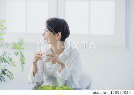 リビングでコーヒーを飲むミドルの女性 リビングでコーヒーを飲むミドルの女性 130923026
