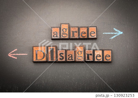 Agree and disagree concept with wooden letter blocks and arrows on chalkboard background Agree and disagree concept with wooden letter blocks and arrows on chalkboard background 130923253