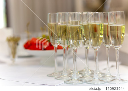Festive table with sweet snacks, fruits, and champagne flutes 130923944