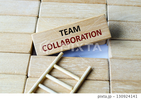 A wooden block showing TEAM COLLABORATION arranged on steps emphasizing synergy, inclusivity, mutual respect and trust. 130924141
