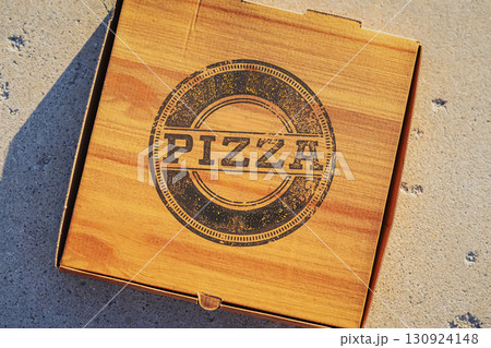 Closed cardboard pizza box with rustic wood-style design and bold "PIZZA" print, no logo, no name. Concept of pizza, food delivery, fast food 130924148