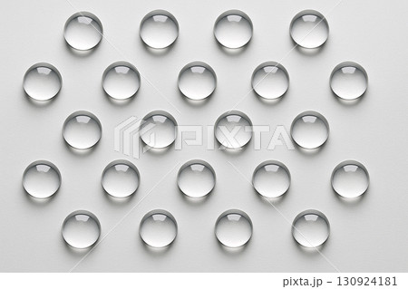 Off white background with arranged transparent droplets in precise symmetrical rows. Off white background with arranged transparent droplets in precise symmetrical rows. 130924181