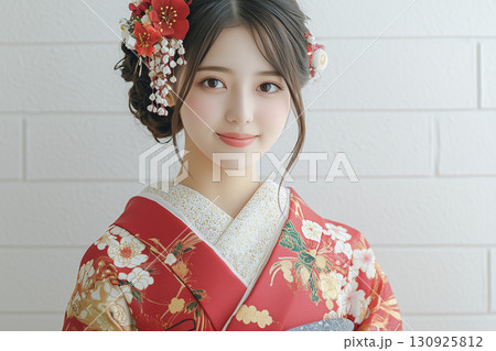 花飾りをつけた日本の伝統的な着物姿の若い女性 130925812