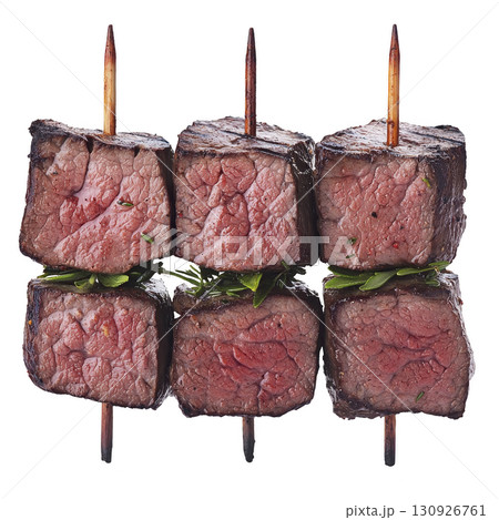 A Juicy grilled beef skewers with herbs, showcasing perfectly cooked medium rare meat. skewers are arranged vertically, highlighting texture and succulence of beef 130926761
