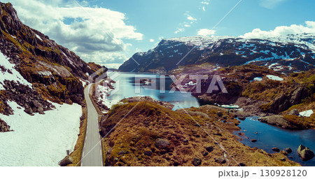 Mountain landscape in summer. Aerial view at glacier melted lake, mountains ridge, and highway. Nature park in Sauda municipality, Rogaland fylke. Beautiful nature of Norway Mountain landscape in summer. Aerial view at glacier melted lake, mountains ridge, and highway. Nature park in Sauda municipality, Rogaland fylke. Beautiful nature of Norway 130928120