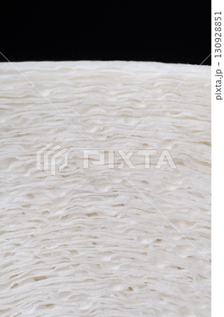 A close-up of a roll of white paper with a distinct texture and three layers of fibers. 130928851
