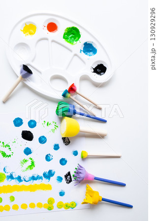 Colorful art tools and paint strokes on white background featuring brushes and palette Colorful art tools and paint strokes on white background featuring brushes and palette 130929296