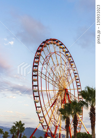 Shot of the ferris wheel, cloudy sky on the background Shot of the ferris wheel, cloudy sky on the background 130931023