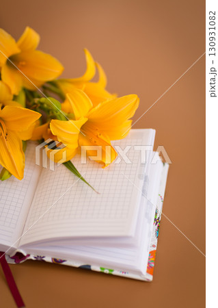 Open journal with bouquet of yellow spring lilies 130931082