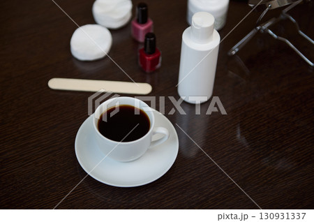 Cup of Coffee on a Wooden Table with Beauty Items Nearby 130931337