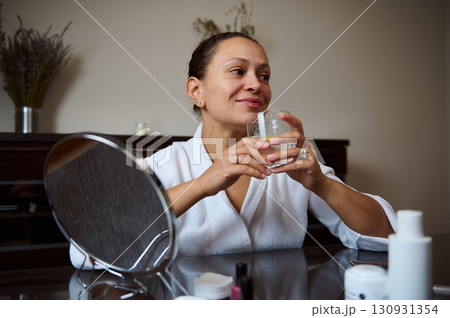Elegant Woman Enjoying a Refreshing Beverage in a Calm Setting 130931354
