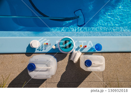 Swimming pool edge with cleaning equipment and maintenance products including chemical canisters, chlorine tablets, dispenser, test kit and submerged vacuum brush 130932018