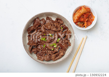 Bulgogi, grilled marinated beef Korean dish with kimchi and sesame seeds top view on white background 130932224