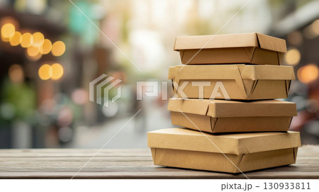 Stack of eco-friendly takeaway food boxes on wooden table, street food delivery concept 130933811