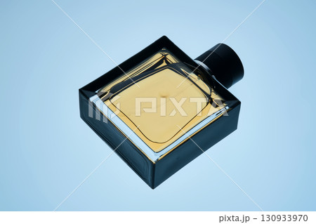 A bottle of perfume with a spray gun on a blue background with an illuminated texture. 130933970